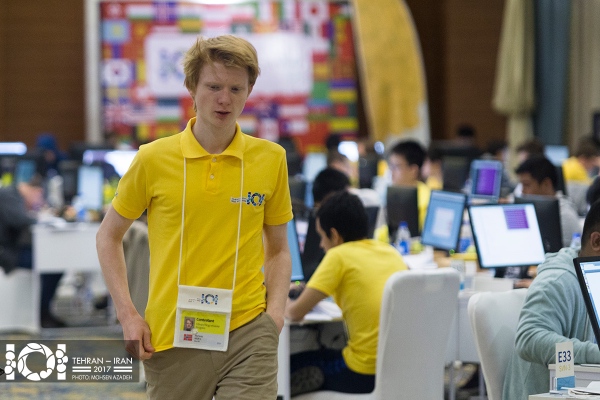Håvard går med en bekymret mine mellom rekkene med deltagerpulter